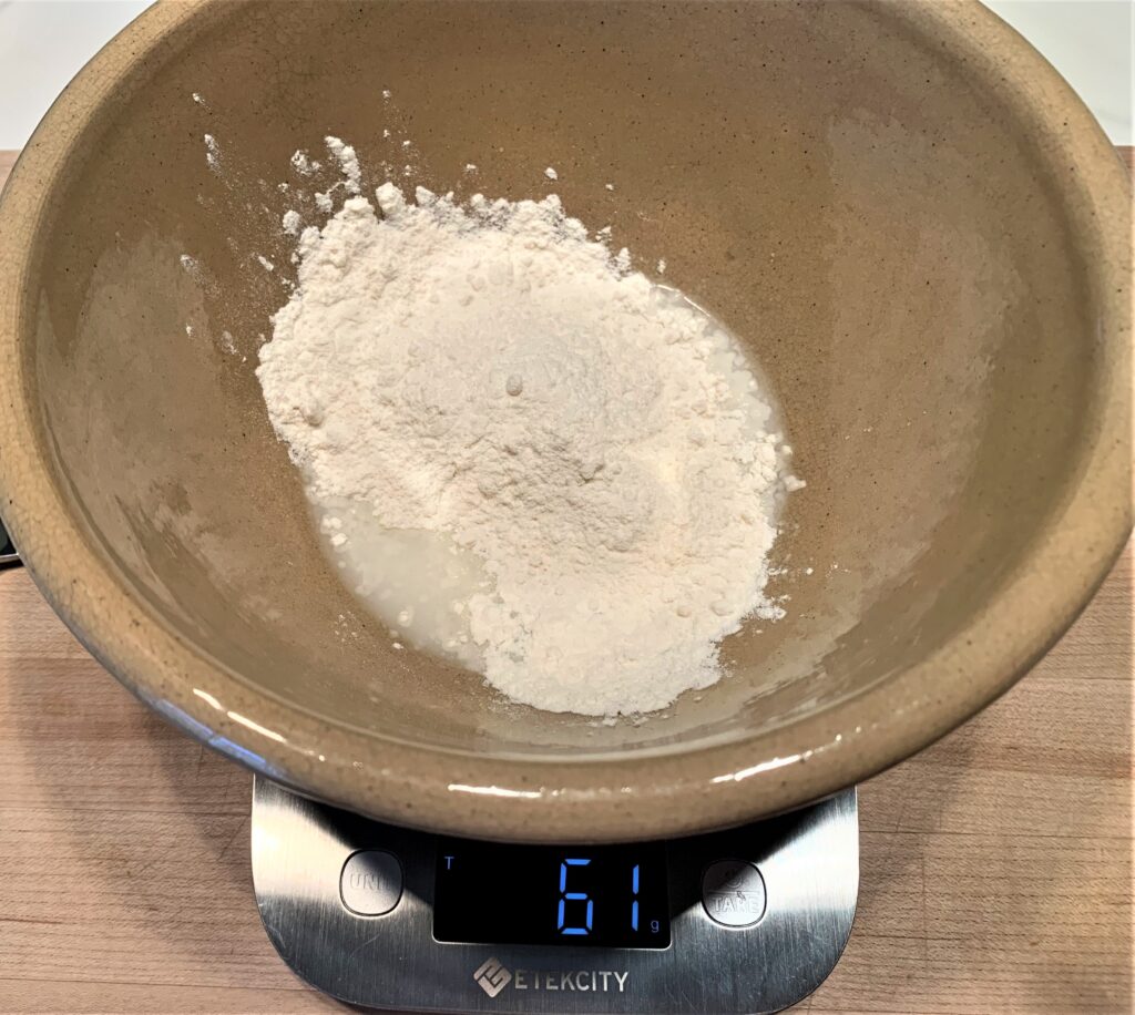 60g of flour added to a bowl with water and starter
