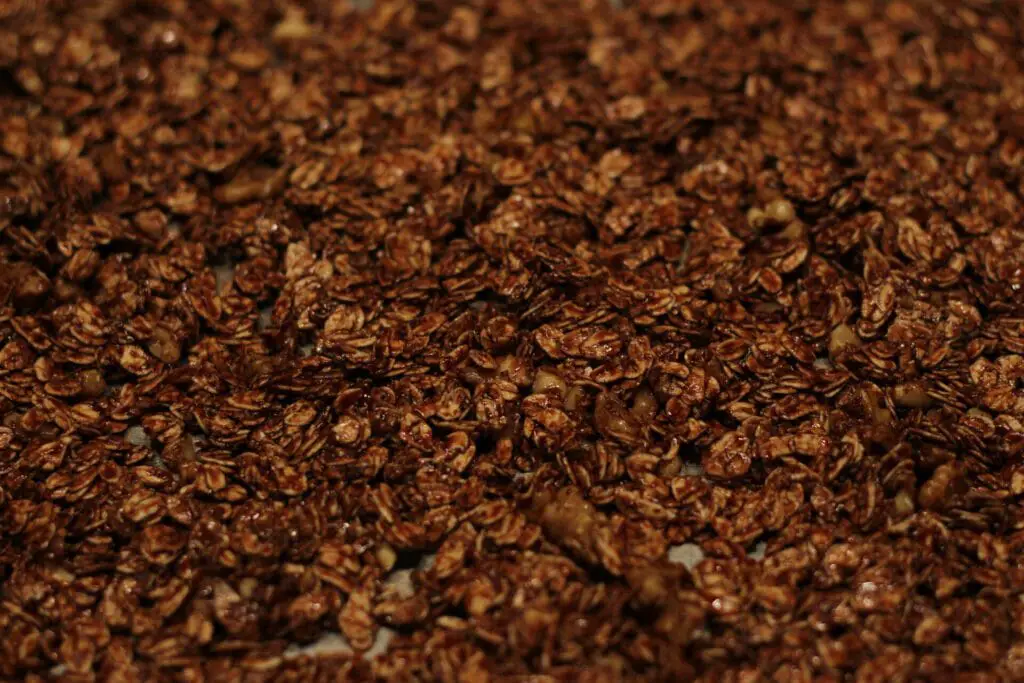 chocolate granola spread out onto a sheet pan