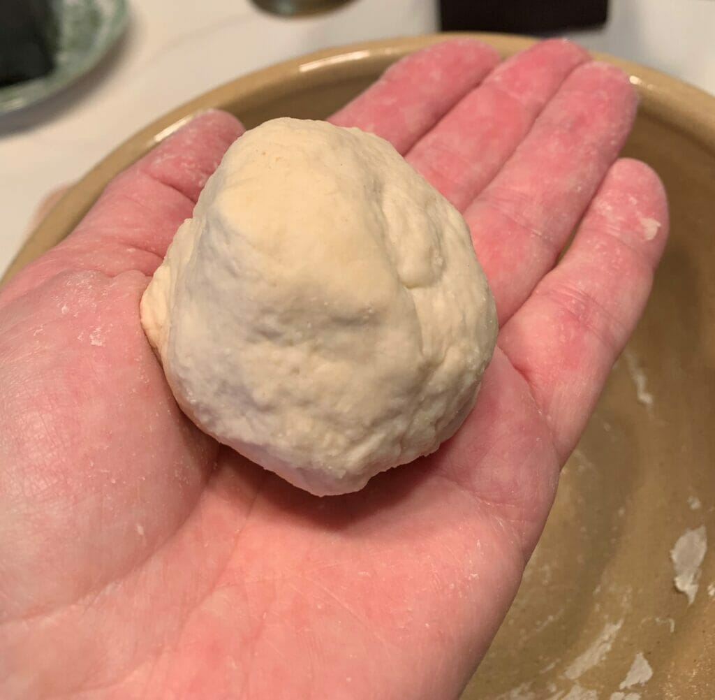 woman's hand with ball of combined starter flour and water