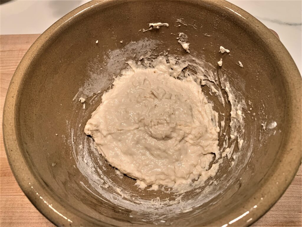 flour water and starter mixed together to form a dough in a bowl 