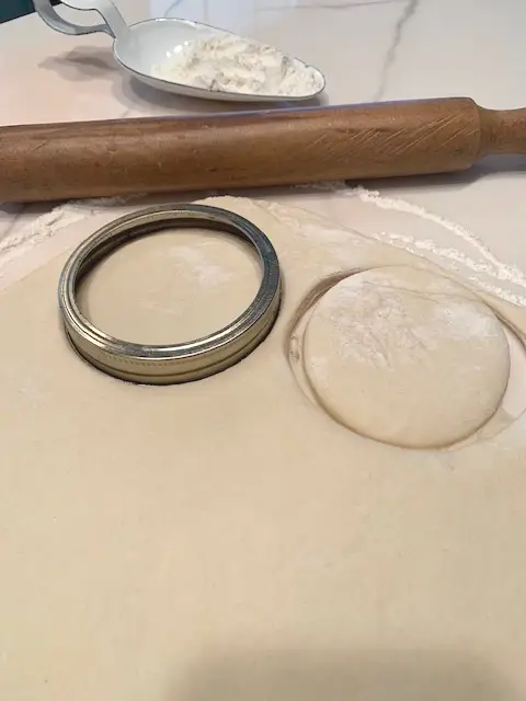 rolled out dough cut with wide mouth canning ring to form rounds of dough