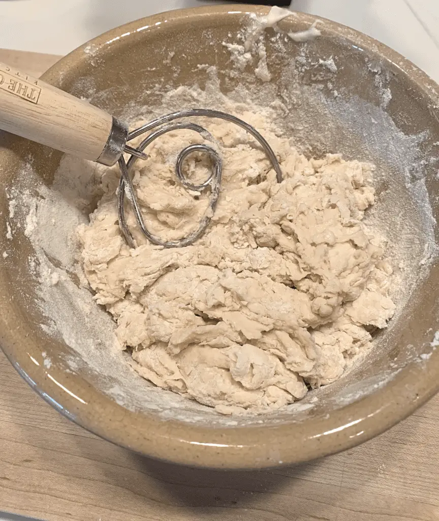 sourdough English muffin dough mixed with dough whisk