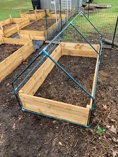 wood raised garden bed with greenhouse frame over it