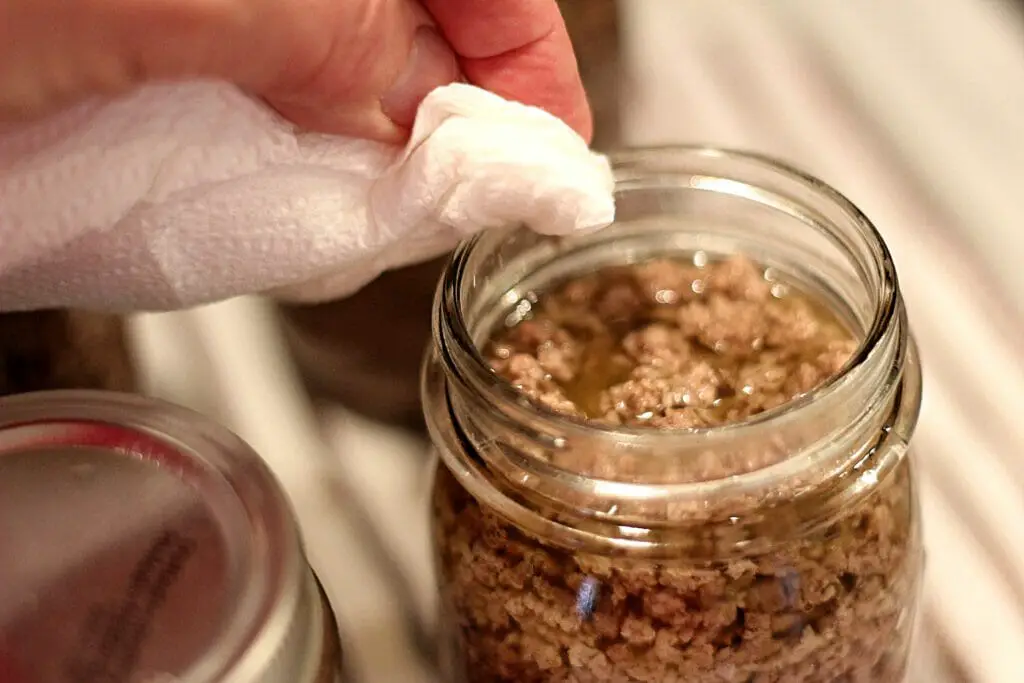 cleaning rim of jar with paper towel and white vinegar