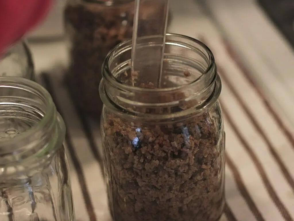 jar of cooked ground beef with plastic bubble remover tool
