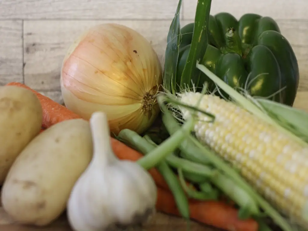 vegetables to make soup: onion, pepper, carrots green beans, corn, and potatoes