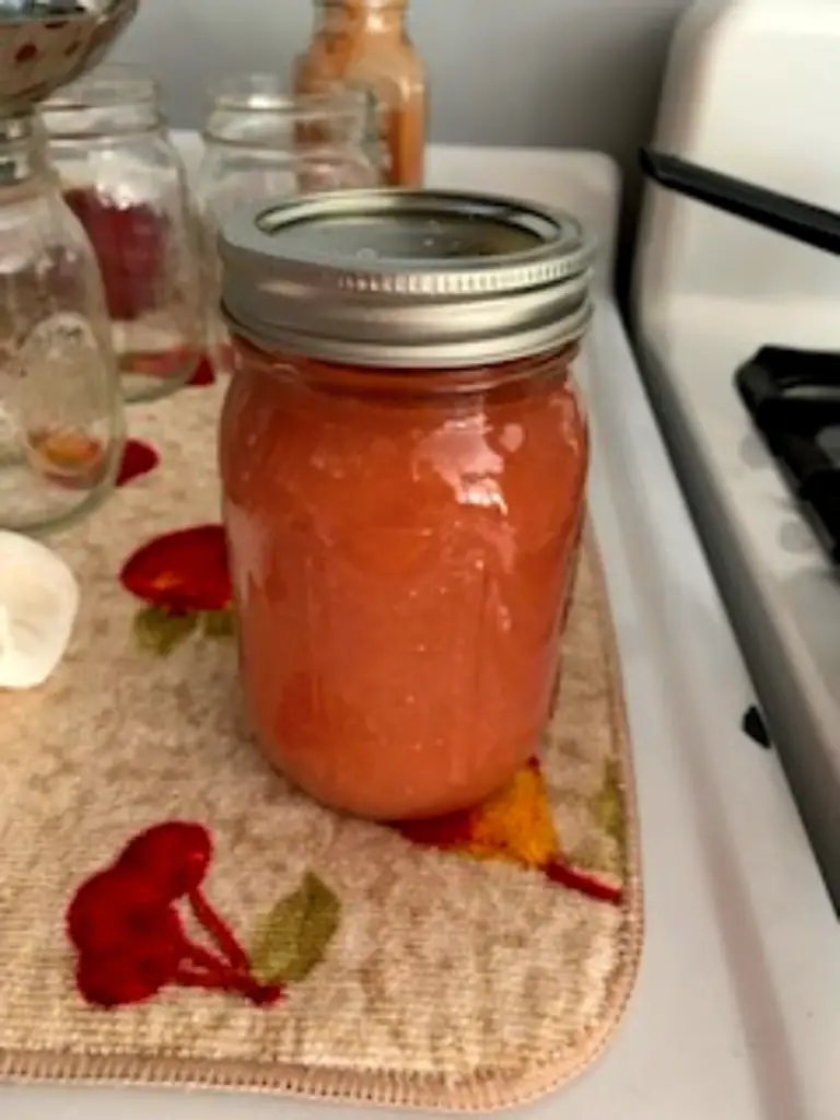 jar of applesauce ready to go into a canner