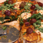 pumpkin pizza with arugula and red grapes