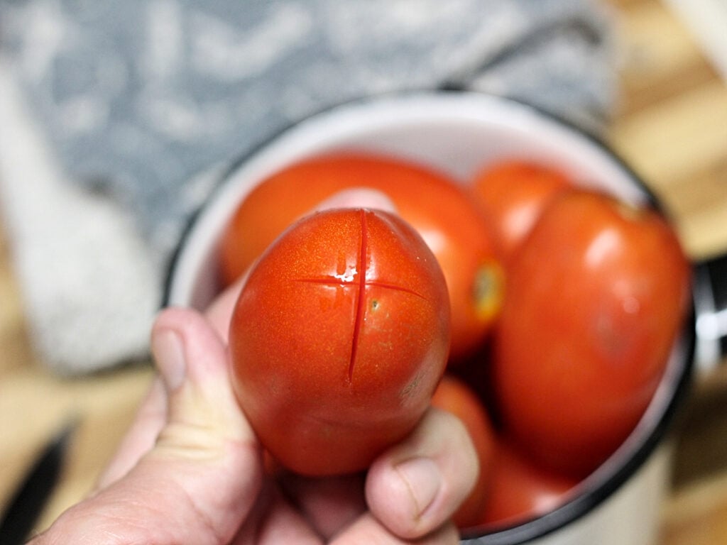 cut an X on the bottom of tomato