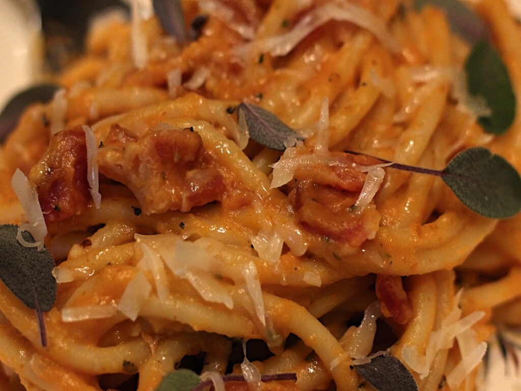 bowl of pumpkin carbonara with crispy bacon and sage